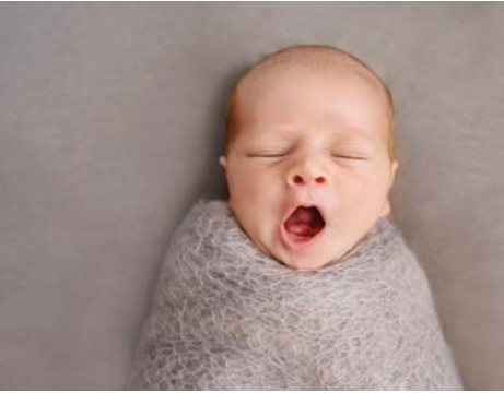 newborn baby swaddled yawning