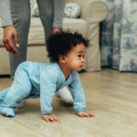 cute baby boy crawling on floor at home