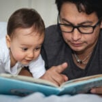 dad and infant reading a book together