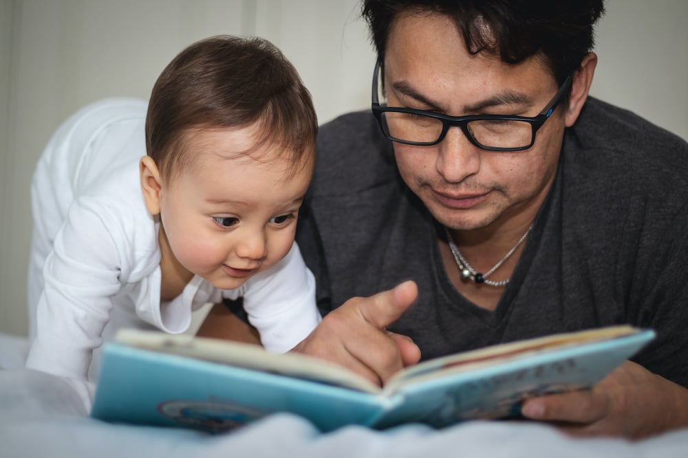 dad and infant reading a book together