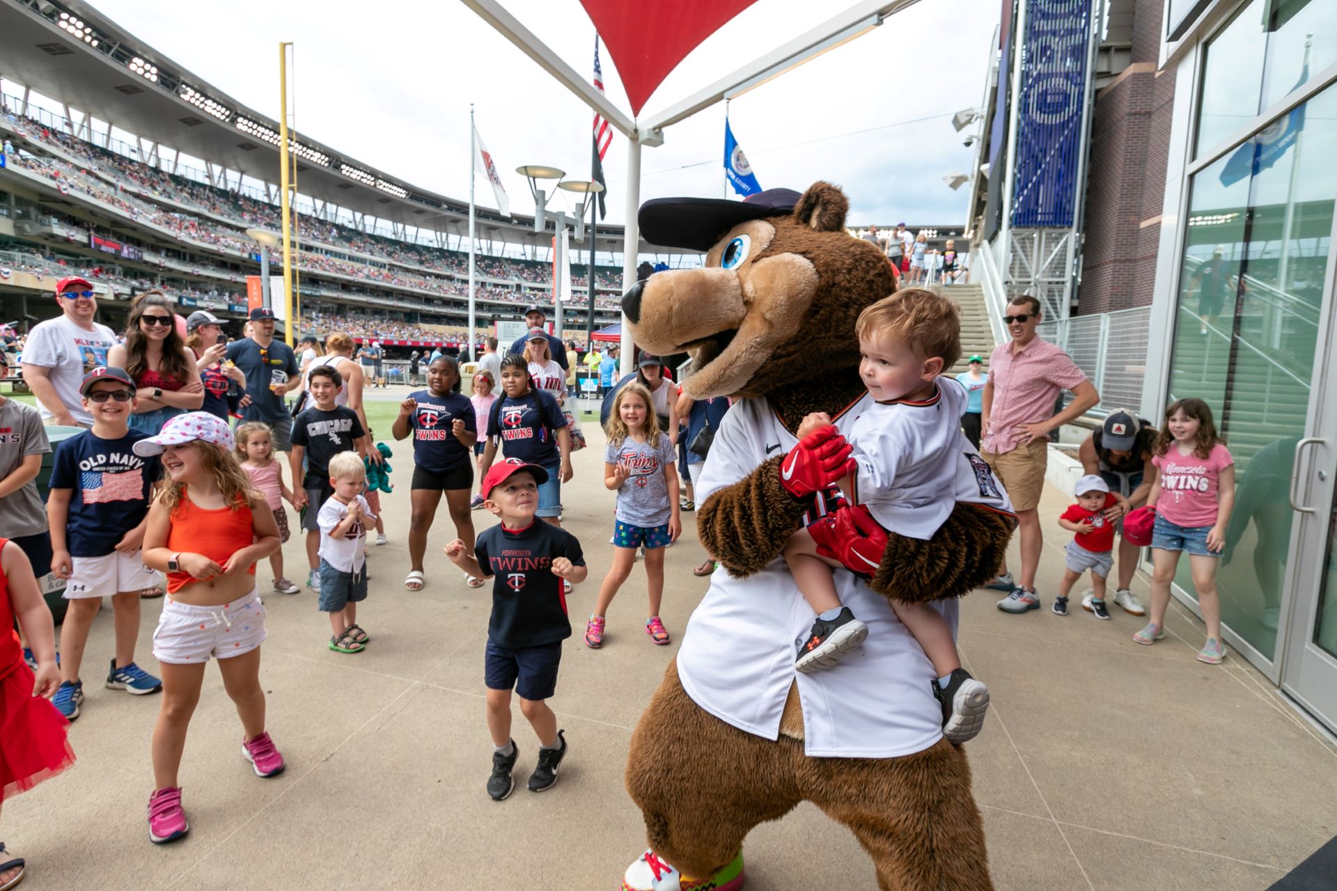 TODDLER boy with tc bear at target field part of Minnesota Twins Family Guide