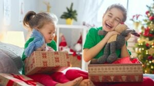 two girls opening gifts on christmas morning