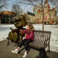 girl sitting on bench in rice park a great stop while in st paul with kids